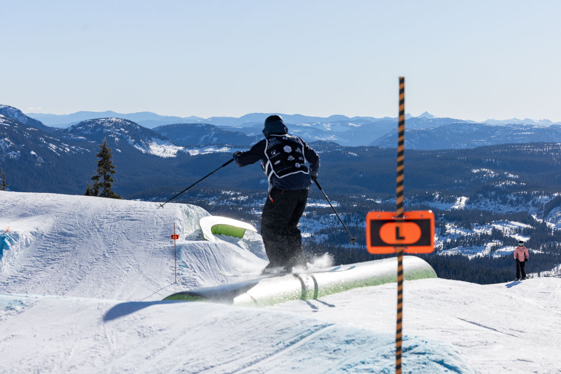 Snowboarder dropping into the terrain park